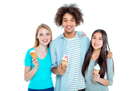 Studio shot of nice young multicultural friends. Beautiful people looking at camera, smiling and holding ice-creams. Isolated backgroundの写真素材