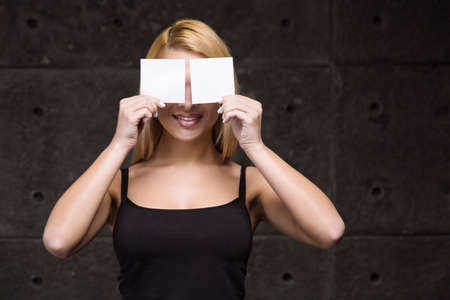 Portrait of stylish beautiful young blonde woman. Woman smiling and holding empty stickersの写真素材