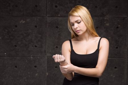 Portrait of stylish beautiful young blonde woman. Woman having wrist painの写真素材