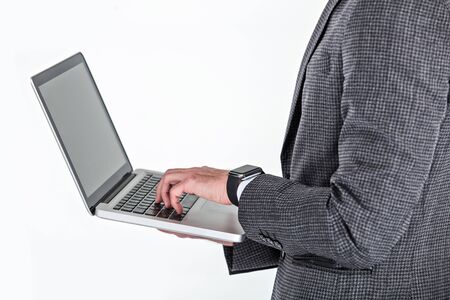 Close up photo of stylish handsome young man isolated on white background. Man with smart watch using laptopの写真素材