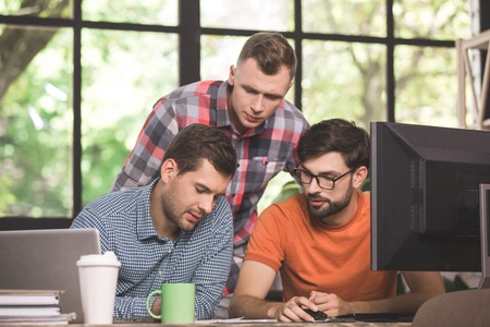 Young men programmers working together in the officeの写真素材