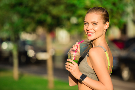 Young woman drink smoothie healthy detox outdoorsの写真素材