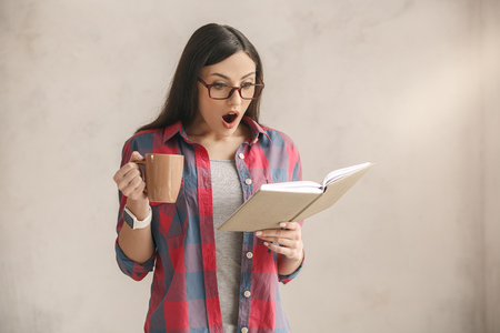 Young woman with a book studio portraitの写真素材