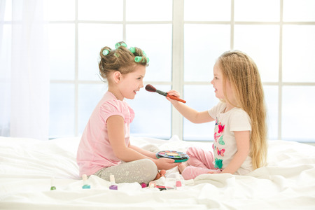 Little kids girls sisters doing makeup indoorsの写真素材