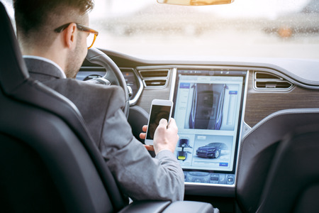 Man transportation by modern eco car using smartphoneの写真素材