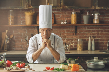 Mature male professional chef cooking meal indoorsの写真素材