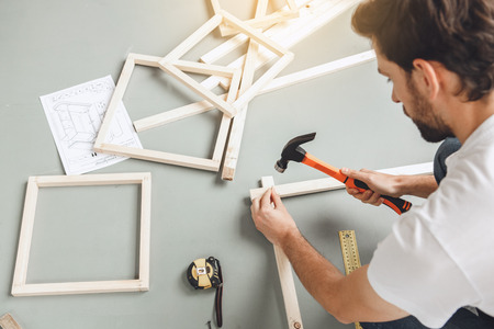 Young man does apartment repairment himself indoorsの写真素材