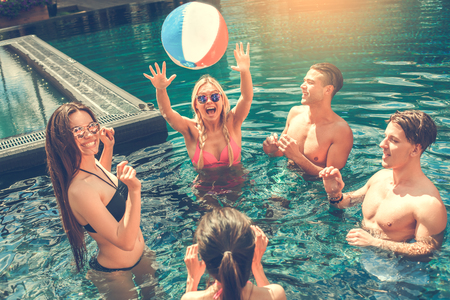Group of friends together in the swimming pool leisureの写真素材