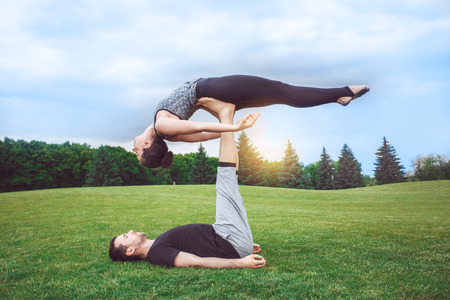 People practice acro yoga outdoors healthy lifestyleの写真素材