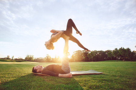 People practice acro yoga outdoors healthy lifestyleの写真素材