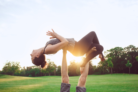People practice acro yoga outdoors healthy lifestyleの写真素材