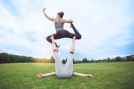 People practice acro yoga outdoors healthy lifestyleの写真素材