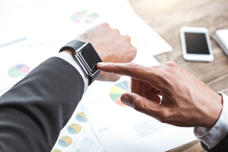 Male person working in the office business checking time