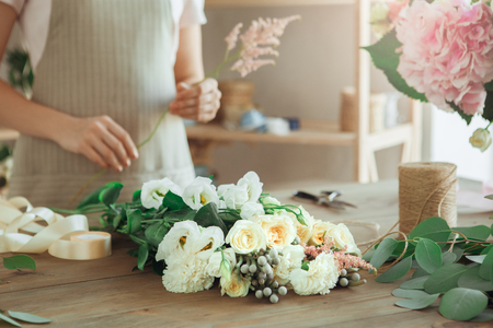 Young woman florist occupation working with flowersの写真素材