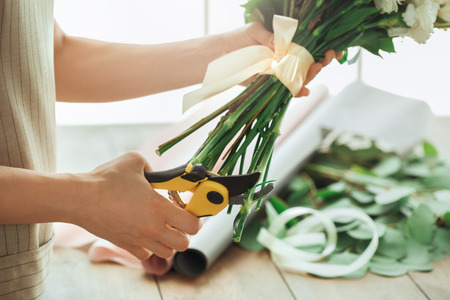 Young woman florist occupation working with flowersの写真素材