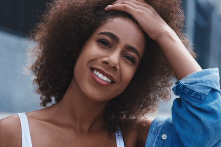 Young woman free style on the street sitting looking camera toucの写真素材