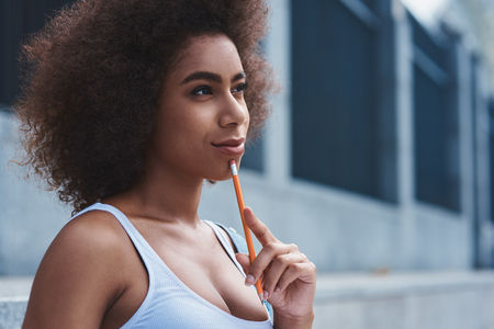 Young woman free style on the street sitting touching chin withの写真素材
