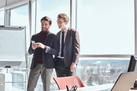 Businesspeople at office working together standing using smartph