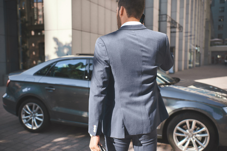 Confident businessman. Young businessman comes to carの写真素材
