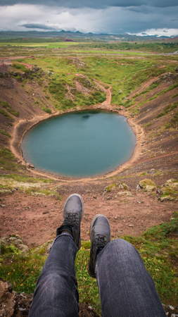 Woman show the blue lake near mountains. Iclandの写真素材