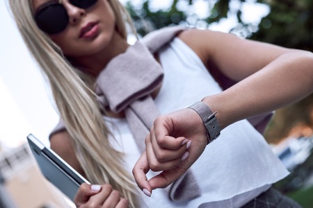Shot of a happy young businesswoman checking the time while wait. Close up view