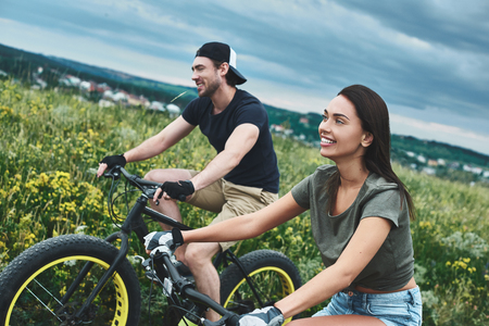 A man and a woman are laughing and cycling. Close up viewの写真素材