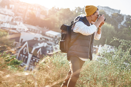 A young stylish blogger tourist is taking photo of of retro buildingsの写真素材