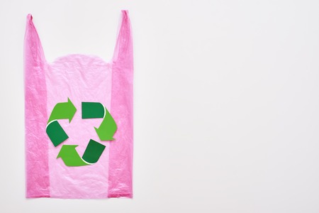 Live green. Isolated recycle symbol at pink plastic bag