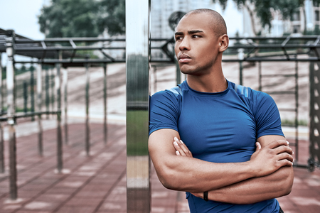 Young african man at the open air gym is resting after doing exercisesの写真素材