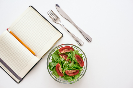 Healthy food preparing. Top view of cookbook for recipe, nearby saladの写真素材