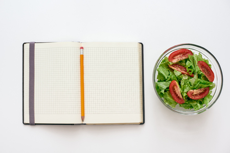 Healthy food preparing. Top view of cookbook for recipe, nearby saladの写真素材