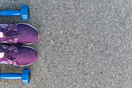 Cropped photo of dumpbells and purple sneakersの写真素材