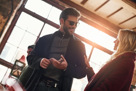 Happy young couple are buying sunglasses at small street marketの写真素材