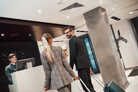 Couple on a business trip doing check-in at the hotelの写真素材