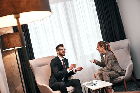 Man and woman drinking coffee in expensive hotel. Business lunchの写真素材