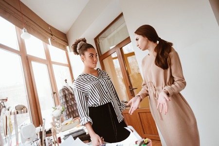 Two young attractive women talking at design studioの写真素材