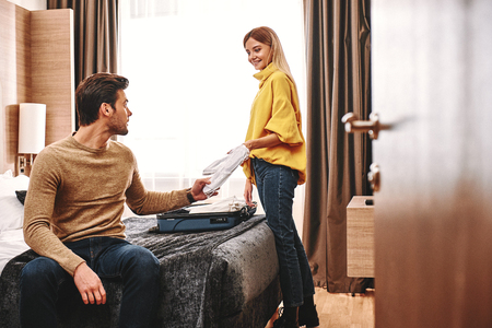 Unpacking things in hotel. Couple adapted to their apartmentの写真素材