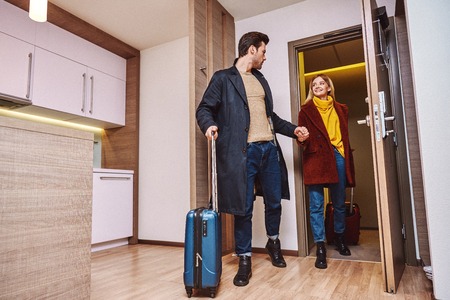 Vacation for couple. Young couple entering the hotel room togetherの写真素材