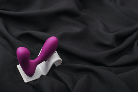 Enhance your sex life. Close up of silicone prostate massager on a black silk fabricの写真素材