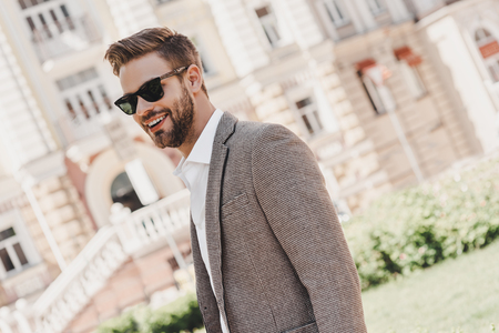 Your limitation - its only your imagination. Portrait of brown-haired man wearing sunglasses and looking away on the city streets.の写真素材