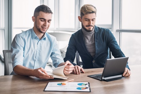 Two businessman in office having discussion in front of computer
