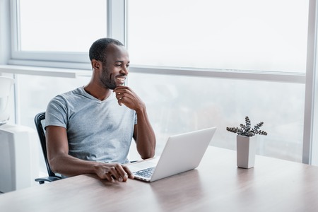 Successful man working at computer in modern officeの写真素材