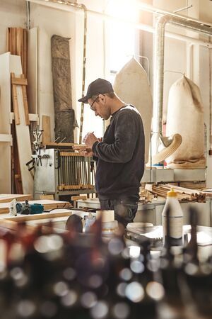 Carpenter using chisel to carve wood in workshop