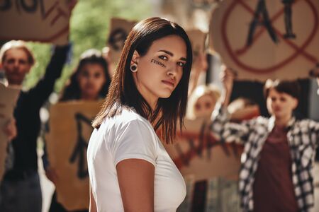 Fighting for my rights. Young activist with word freedom written on her face looking at camera while...