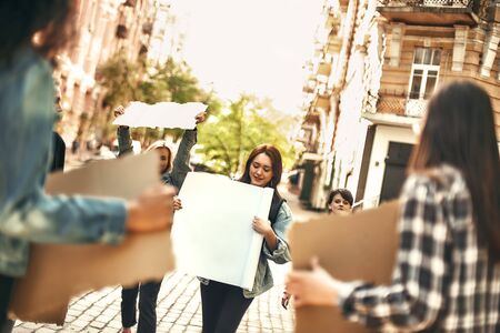Protesting outdoors. Group of positive female activists holding sign boards while demonstrating on the road. Womens marchの写真素材