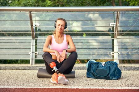 Confident in myself. Portrait of young woman in sports clothing and headphones with leg prosthesis...