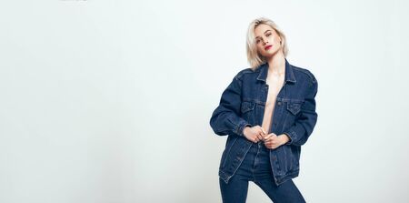 Confident in my style. Cute young woman in jeans wear looking at camera while standing against grey...