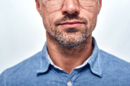 Perfect look. Cropped photo of bearded man in eyewear looking at camera while standing against grey...