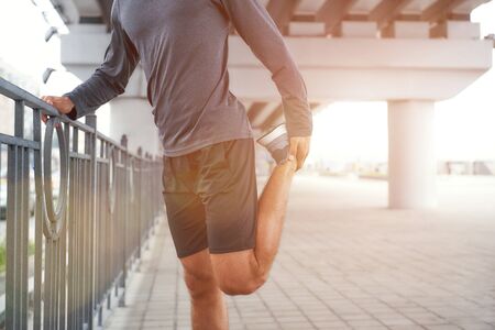 Starting my workout. Cropped photo of a man in sportswear stretching his leg while standing outdoors