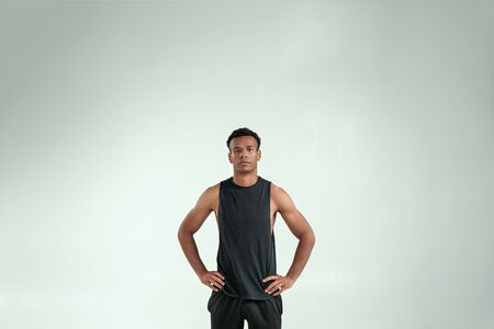 Strength and Motivation. Handsome young afro american man keeping arms on hips and looking at camera...
